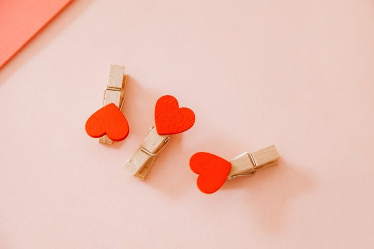 Close-up of three heart-shaped wooden clothespins to respresent relationship and attachment style