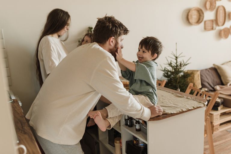 A father and son share a loving moment indoors, capturing family warmth and successful parenting tips.